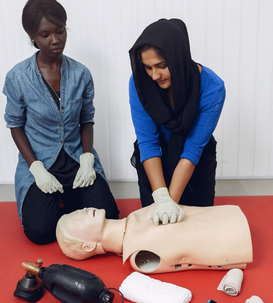 Medical students are practicing. Ladys provide first aid. Women in medical gloves performs resuscitation.
