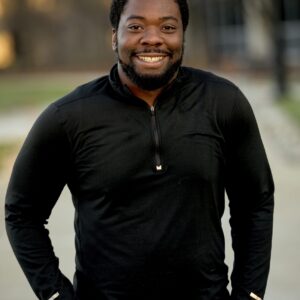 A vertical shot of an attractive African American male smiling at the camera